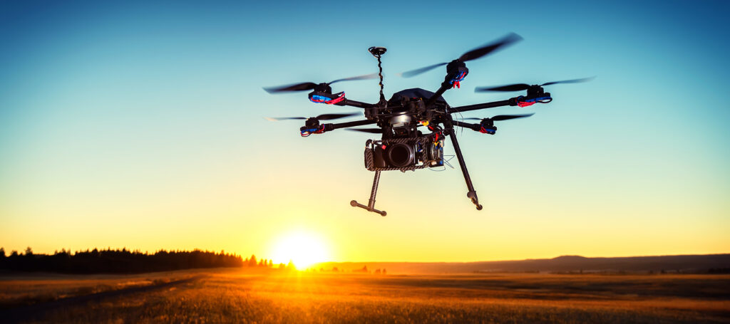 Drone hovers above a golden field at sunset