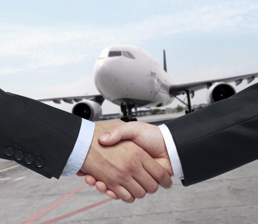 businessman handshaking in front of a huge jumbo jet