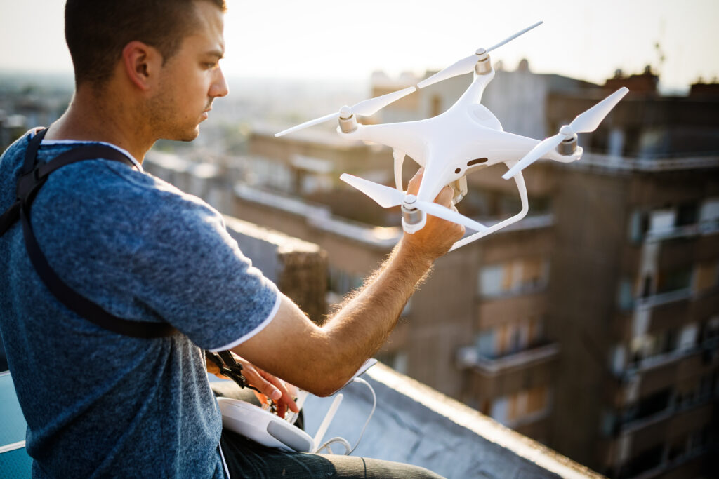 close up shot of man holding white drone with blurred background