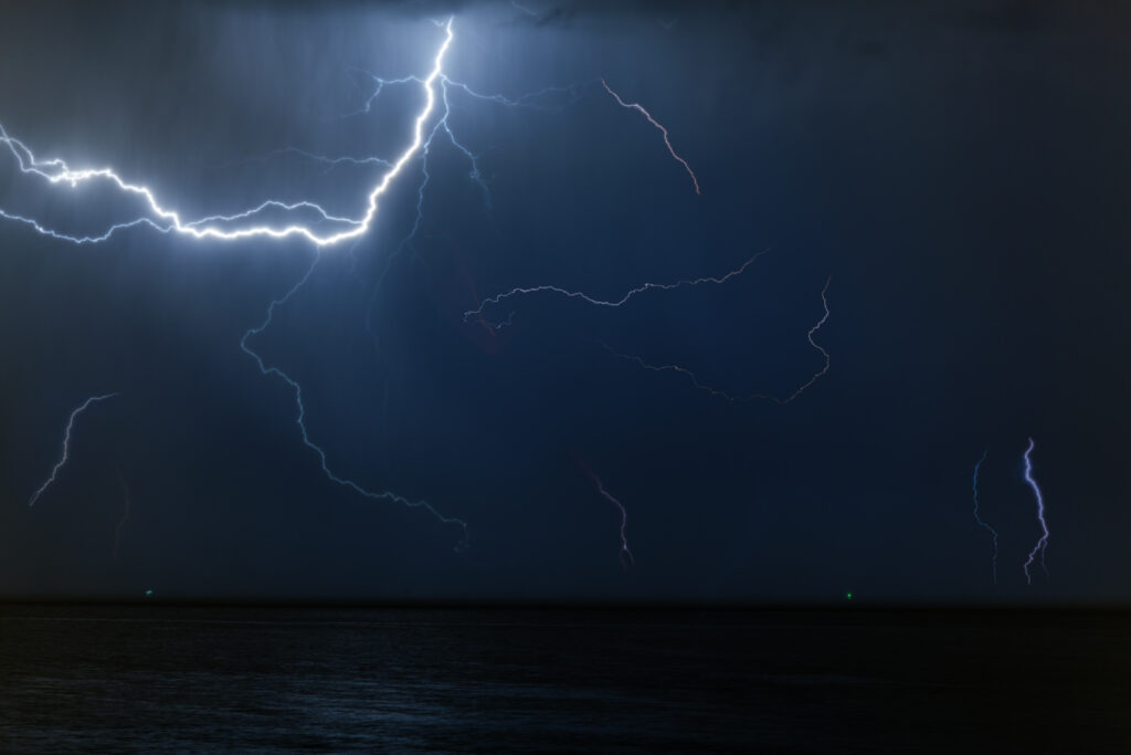 Thunderstorm lightning over ocean at night.
